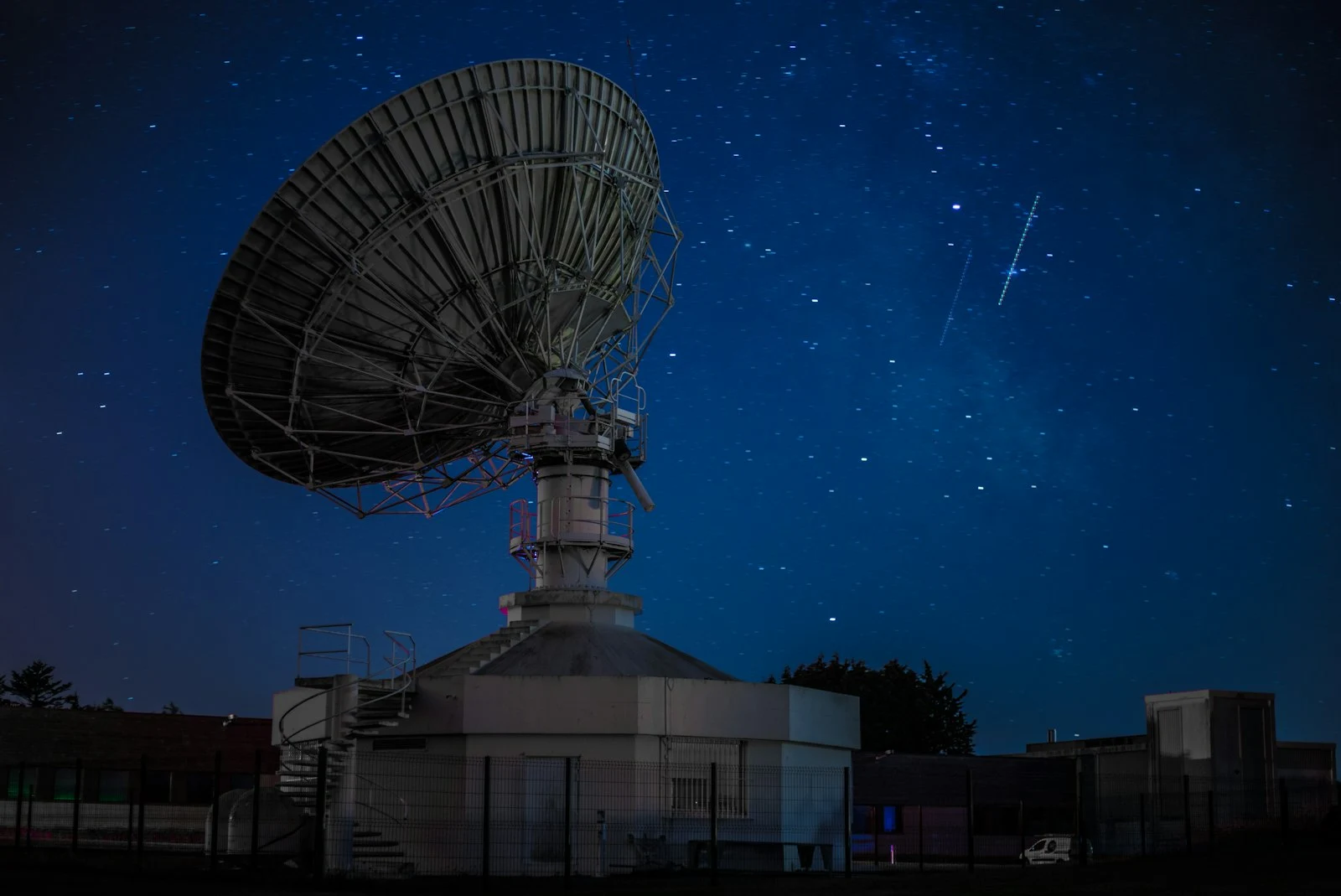 A radio telescope reaching into a sky filled with stars